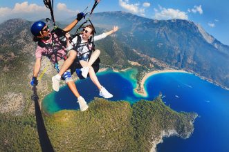 Adventure seekers enjoy paragliding over the stunning Blue Lagoon in Ölüdeniz, Turkey.