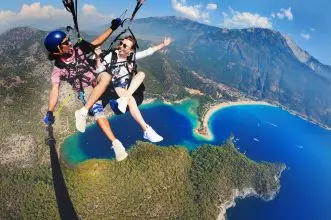 Adventure seekers enjoy paragliding over the stunning Blue Lagoon in Ölüdeniz, Turkey.