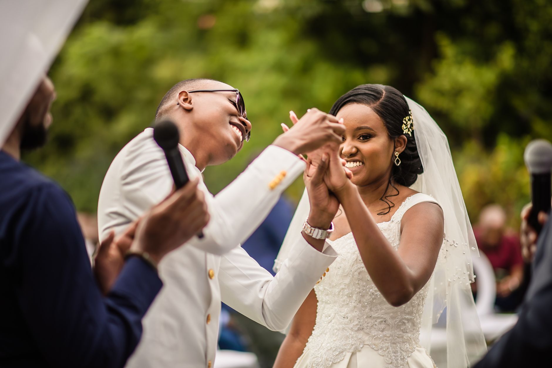 African couple deeply in love, dancing and smiling at their wedding ceremony.