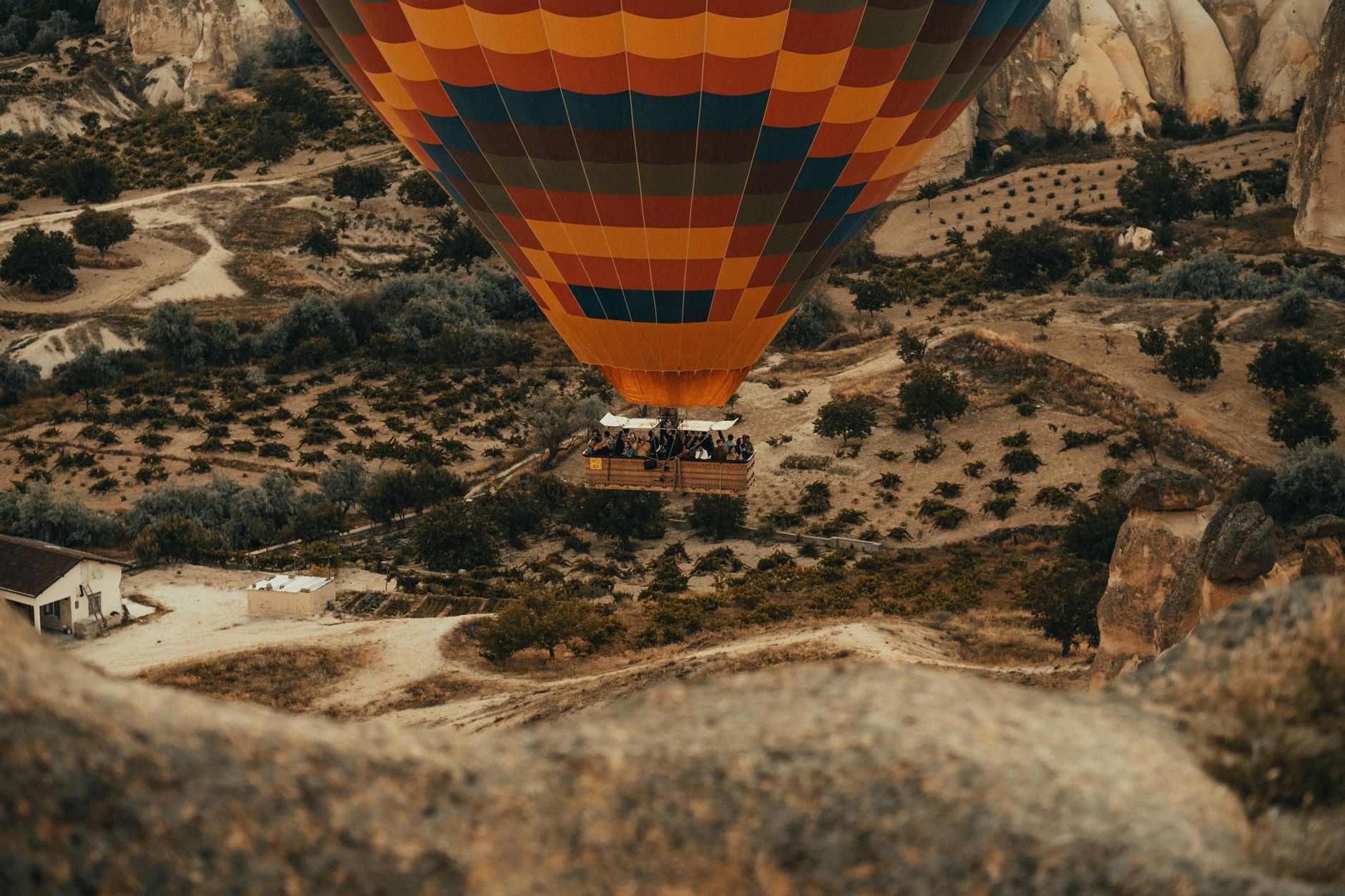 Vibrant hot air balloon soaring over the scenic landscapes of Cappadocia, Turkey.