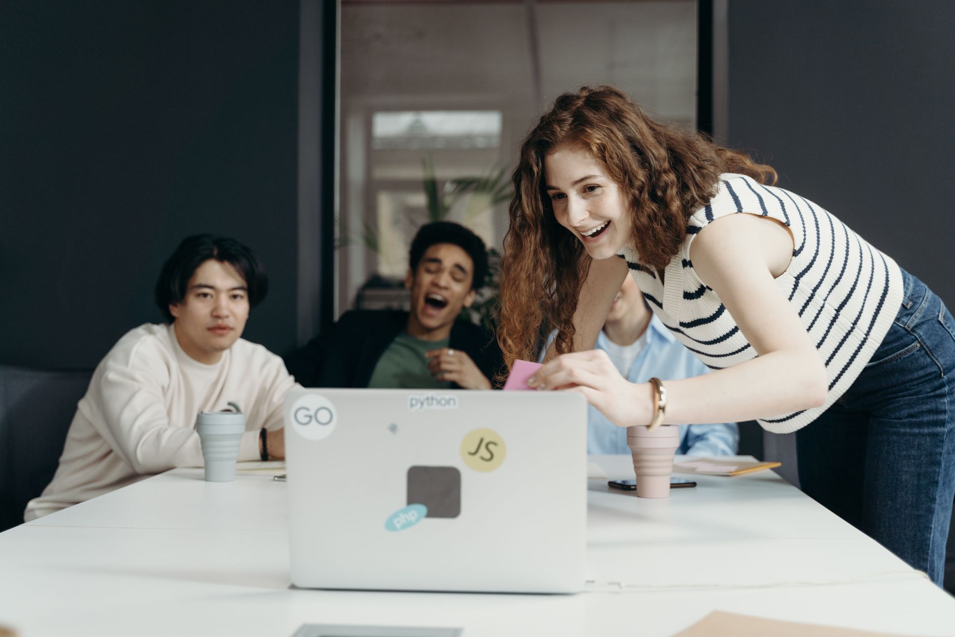 A diverse group of young professionals collaborating enthusiastically in an office setting.