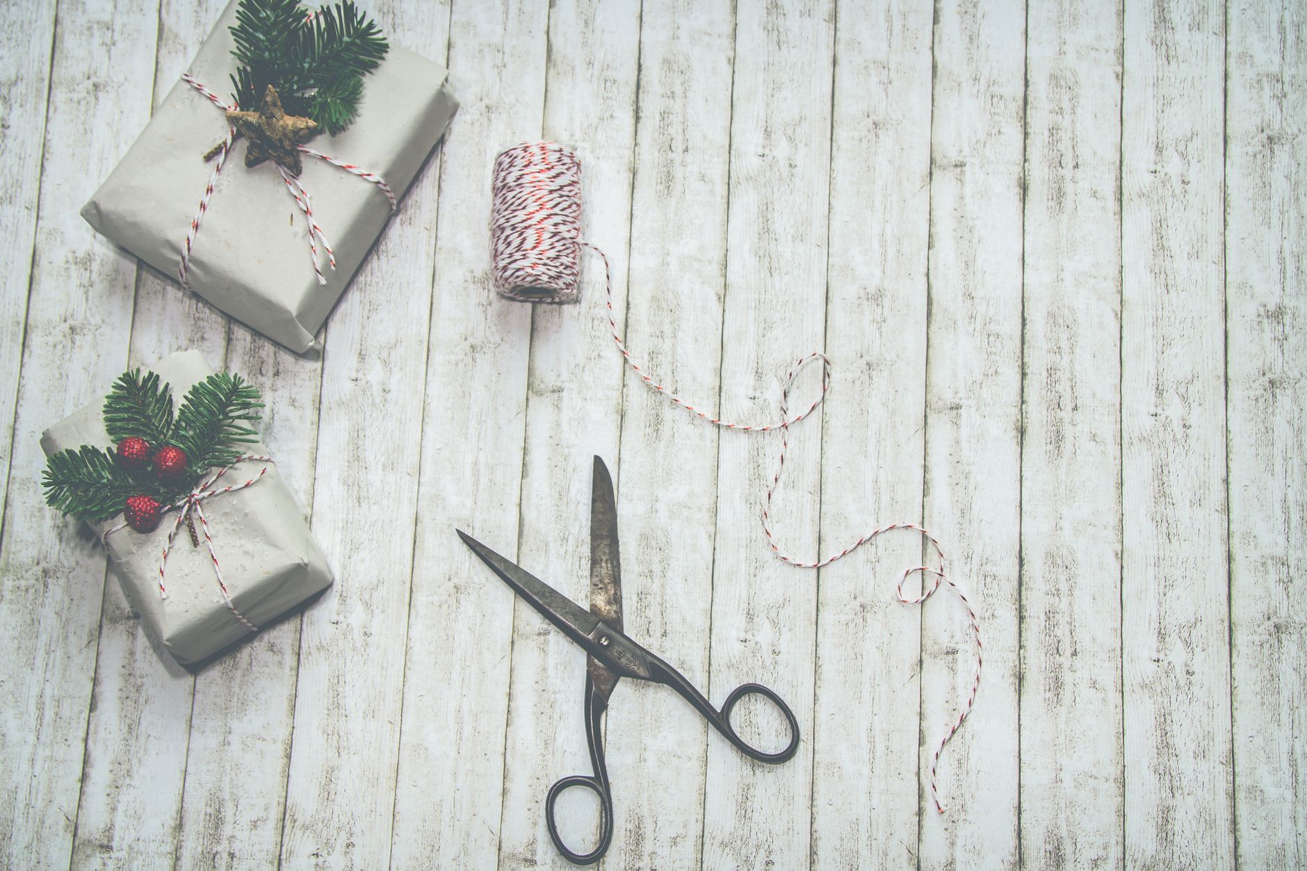 Festive Christmas presents with rustic wrapping and decorations on a wooden backdrop.