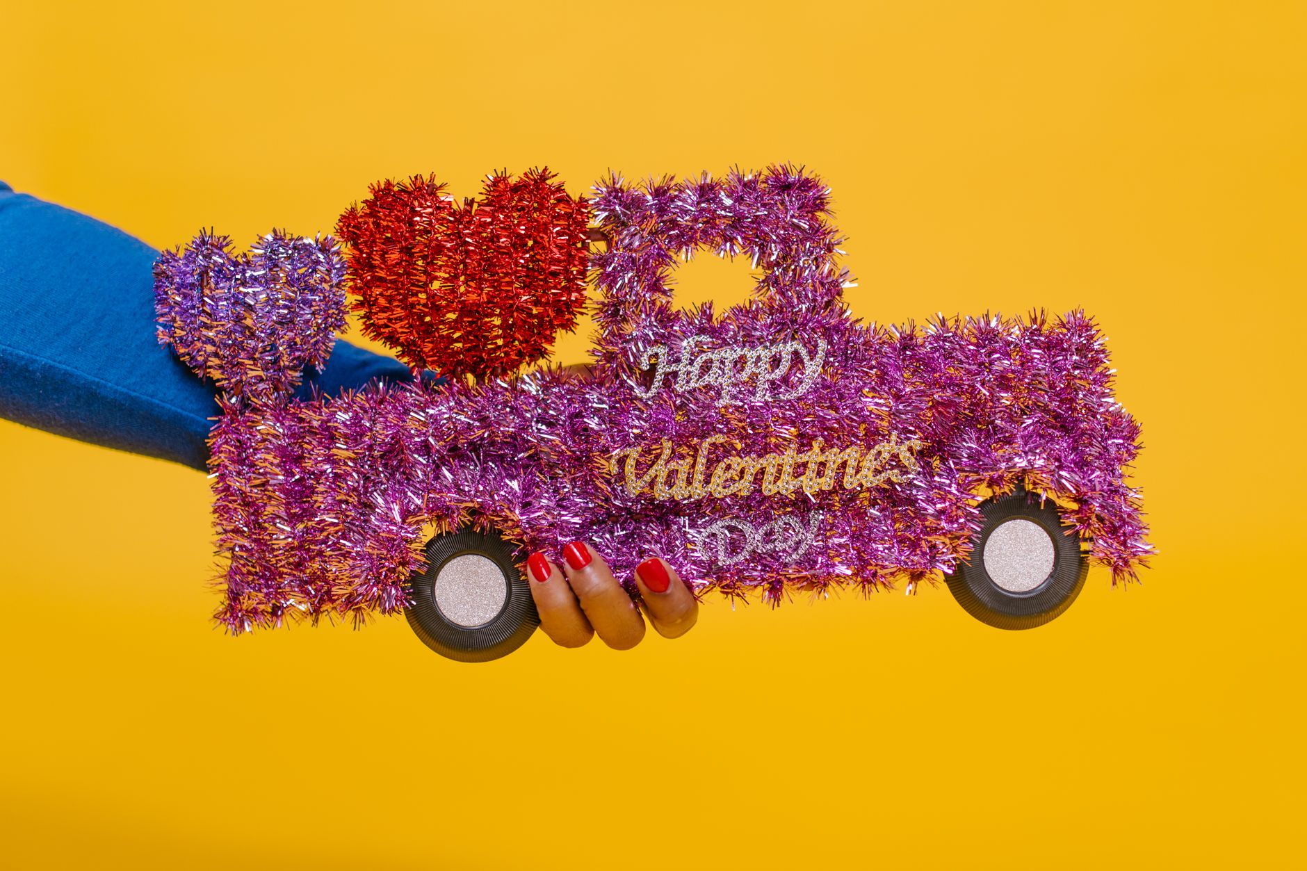 A colorful Valentine-themed truck decoration against a vibrant yellow background.
