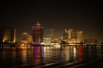 Captivating night shot of New Orleans skyline reflecting on the Mississippi River.