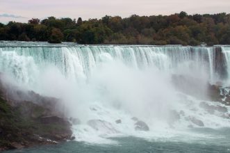 Breathtaking view of Niagara Falls surrounded by autumn foliage and mist.