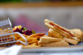 A delectable toasted sandwich paired with crispy golden French fries, perfect for a lunch snack.