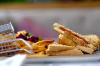 A delectable toasted sandwich paired with crispy golden French fries, perfect for a lunch snack.