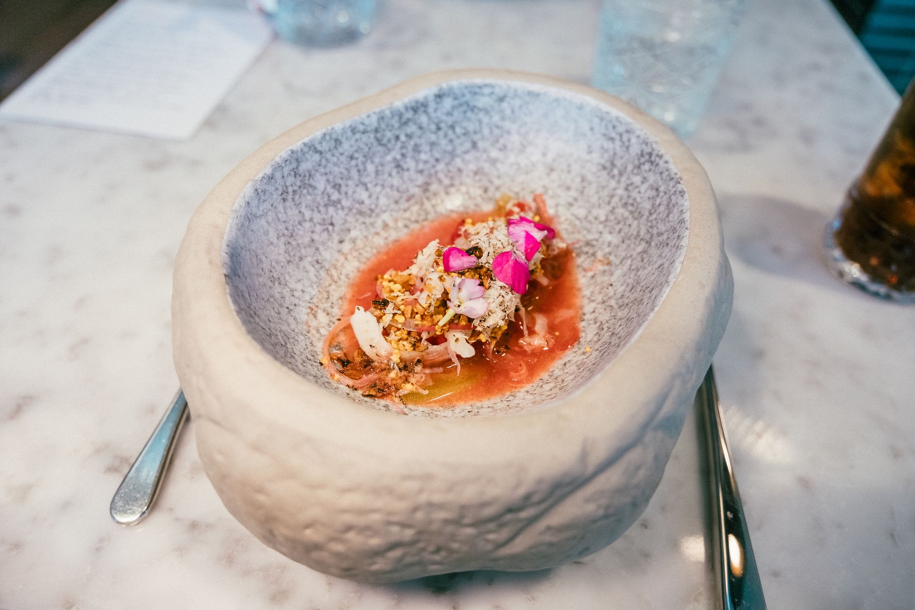 A beautifully plated gourmet dish served in a unique ceramic bowl on a fine dining table.