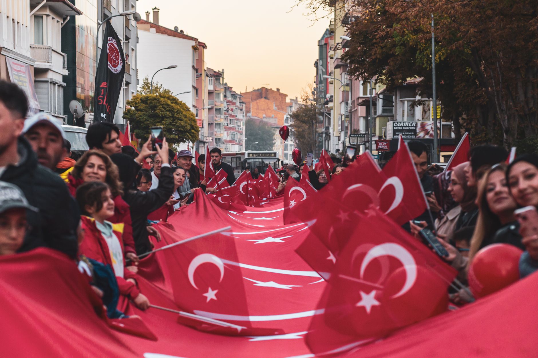 Vibrant street parade in Afyonkarahisar celebrating with Turkish flags and national pride.