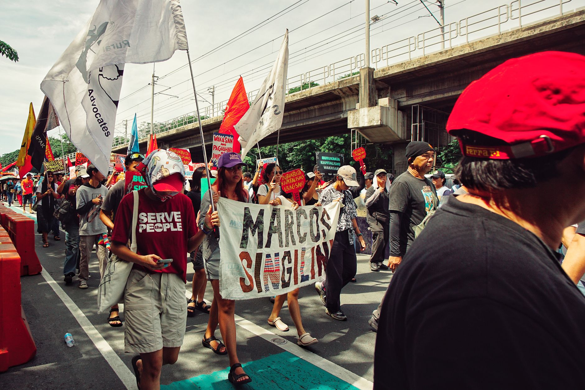 A group of people in a political rally with banners and flags showing social and political activism.